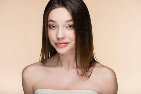 Pretty young woman with bare shoulders smiling isolated on beige — Stockfoto