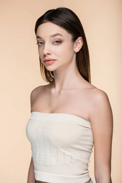 Confident woman in crop top with bare shoulders isolated on beige — Stock Photo