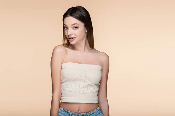 Flirty woman in crop top with bare shoulders isolated on beige — Stock Photo