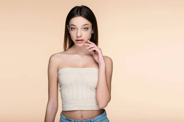 Young woman in crop top looking at camera isolated on beige — Stock Photo