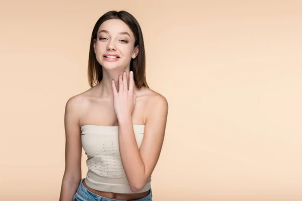 Fröhliche junge Frau in Crop Top isoliert auf beige — Stockfoto