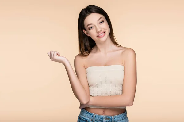 Cheerful and pretty woman in crop top isolated on beige — стоковое фото