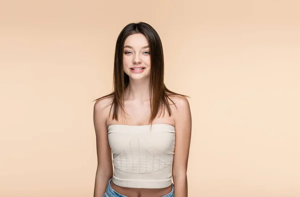 Positive and pretty woman in crop top isolated on beige — Fotografia de Stock