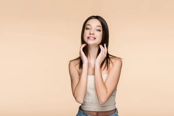 Pleased and pretty woman in crop top isolated on beige — Stockfoto