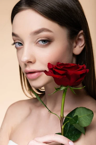 Young woman with bare shoulders near rose isolated on beige — Fotografia de Stock