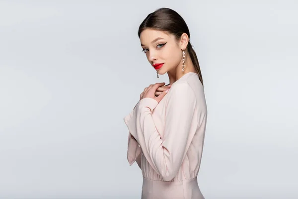 Jeune femme sensuelle avec des lèvres rouges regardant la caméra isolée sur gris — Photo de stock