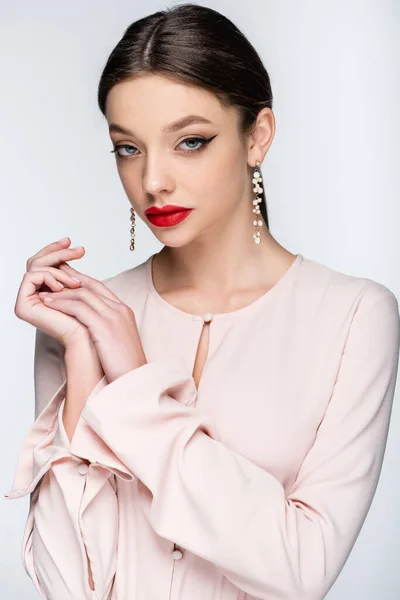 Jolie femme avec des lèvres rouges regardant la caméra tout en posant isolé sur gris — Photo de stock