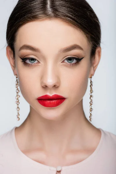 Jolie femme en boucles d'oreilles regardant caméra isolée sur gris — Photo de stock