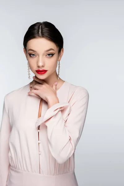 Woman in earrings and blouse looking at camera isolated on grey — Stockfoto