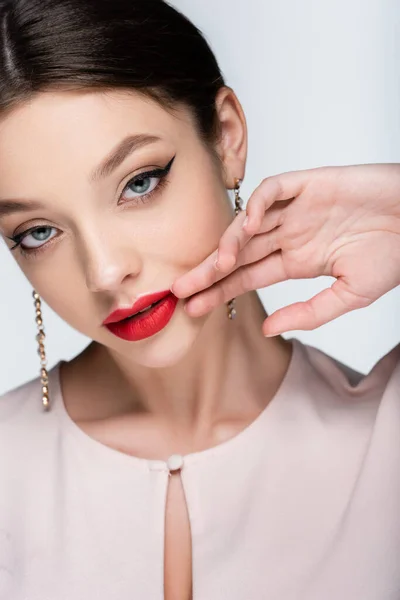 Mujer joven y bonita con maquillaje brillante posando aislado en gris - foto de stock