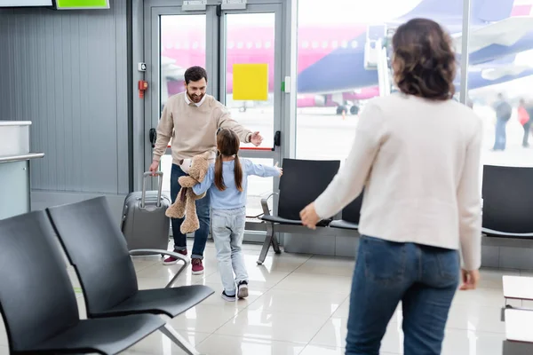 Дівчина зустрічає щасливого батька з валізою в аеропорту — стокове фото