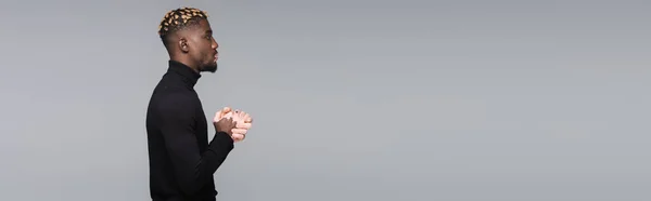 Side view of african american man with vitiligo and trendy hairstyle isolated on grey, banner - foto de stock