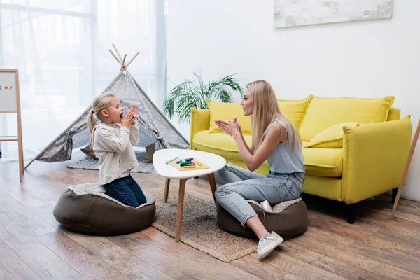 Side view of family warming plasticine near couch at home — Fotografia de Stock