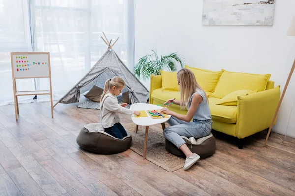 Side view of mother and child modeling plasticine at home — Stockfoto