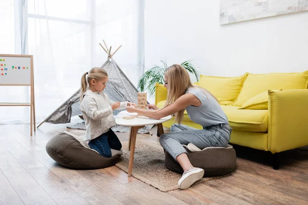 Mother and daughter playing wood blocks game at home — Stock Photo