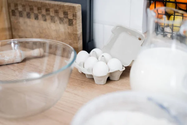 Uova vicino mattarello e ciotola in cucina — Foto stock