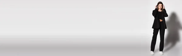 Vista integrale della donna bruna in abito nero e scarpe da ginnastica bianche che toccano i capelli grigi con ombra, banner — Foto stock