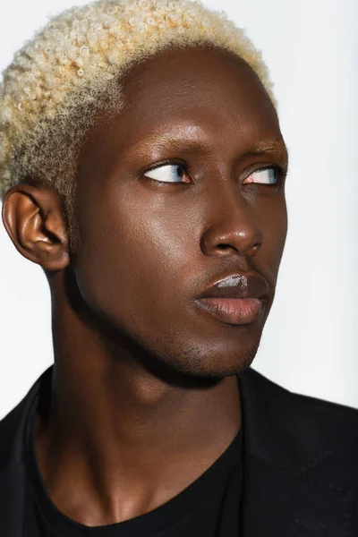 Close up portrait of young african american man with blonde hair isolated on grey — Stock Photo