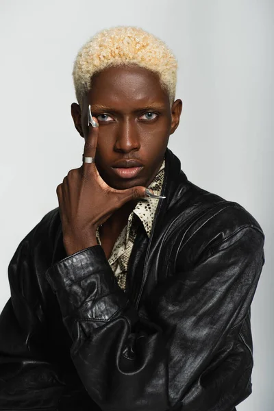 Élégant homme afro-américain avec ongles argentés posant avec la main près du visage isolé sur gris — Photo de stock