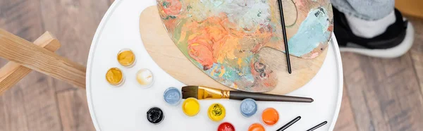 Top view paintbrushes near paints at home, banner — Stock Photo