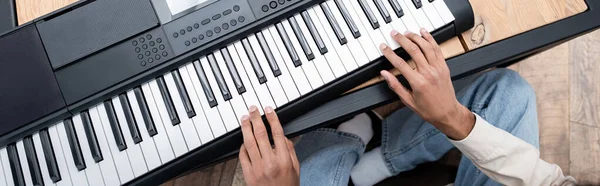 Cropped view of african american man playing synthesizer at home, banner — Stock Photo