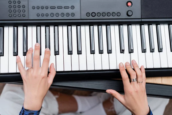 Cropped view of african american woman playing synthesizer at home — Stock Photo