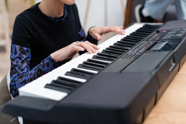 Cropped view of african american woman playing blurred synthesizer at home — Stock Photo