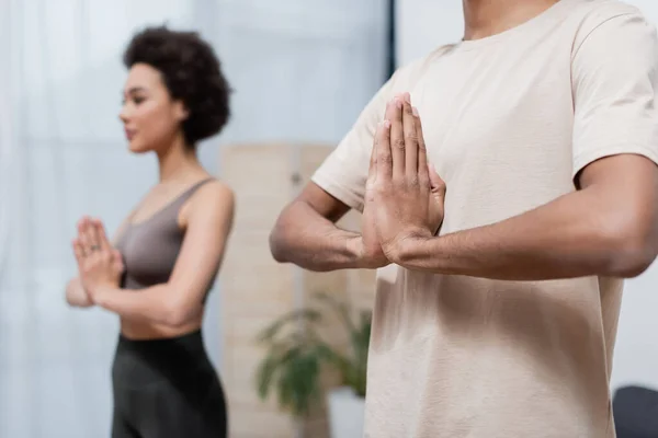 Africain américain pratiquant le yoga près de petite amie floue à la maison — Photo de stock