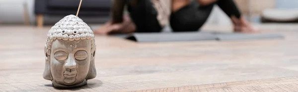 Incense stick near blurred african american couple on yoga mats at home, banner — Stock Photo