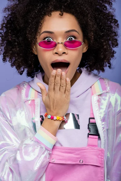 Schockierte Afroamerikanerin mit offenem Mund blickt isoliert auf lila Kamera — Stockfoto