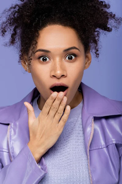 Mujer afroamericana conmocionada con la boca abierta aislada en púrpura - foto de stock