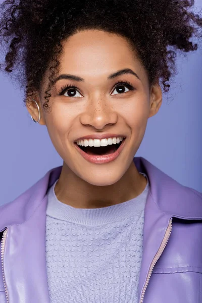 Excitada joven afroamericana aislada en púrpura - foto de stock
