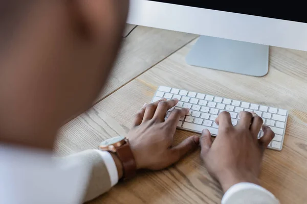 Vue recadrée de l'homme afro-américain tapant sur le clavier de l'ordinateur — Photo de stock