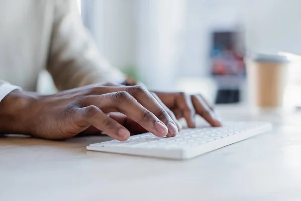 Vista parcial del hombre afroamericano escribiendo en el teclado de la computadora - foto de stock
