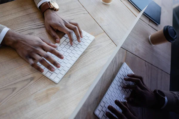 Vista superior del hombre afroamericano escribiendo en el teclado de la computadora - foto de stock
