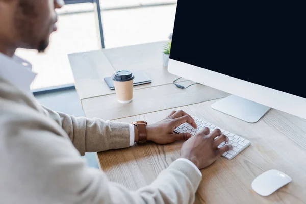 Cropped view of young african american man typing on computer keyboard in office — Stock Photo