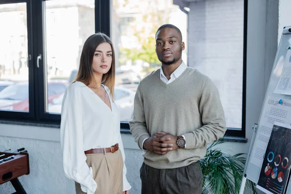 Interracial Geschäftsmann und Geschäftsfrau posiert im Büro — Stockfoto