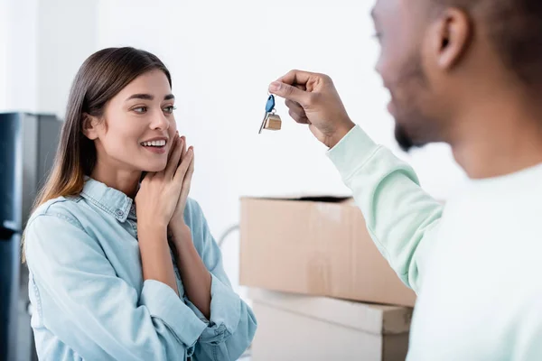 Desfocado afro-americano homem segurando chave de novo apartamento perto alegre namorada — Fotografia de Stock