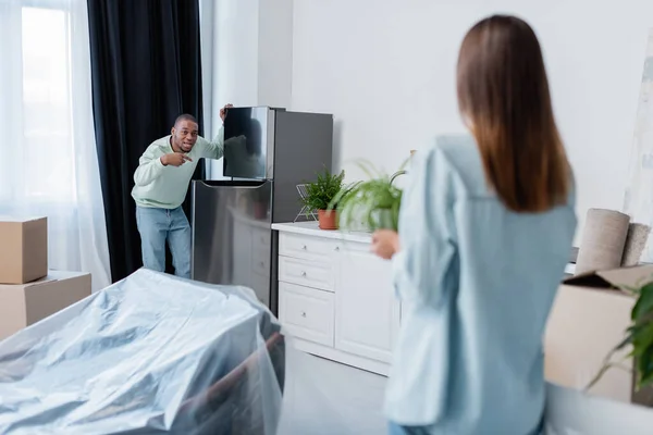 Displeased african american man quarrelling with girlfriend during relocation — Stock Photo
