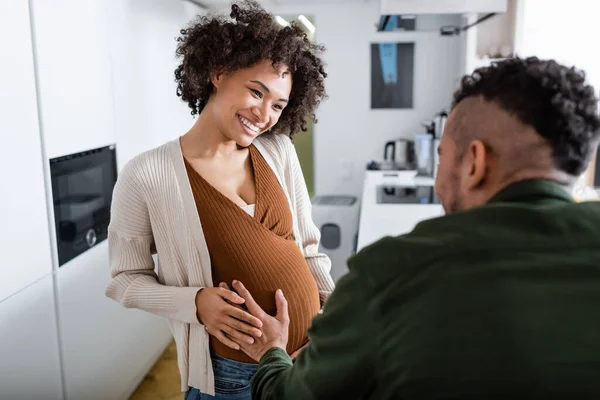 Desenfocado africano americano hombre tocando vientre de embarazada esposa — Stock Photo