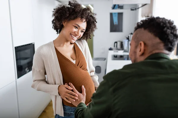 Blurred african american man touching belly of pregnant wife — Stock Photo