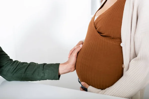 Vue recadrée de l'homme afro-américain touchant le ventre de la femme enceinte — Photo de stock