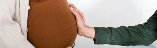 Cropped view of african american man touching belly of pregnant wife, banner — Stock Photo