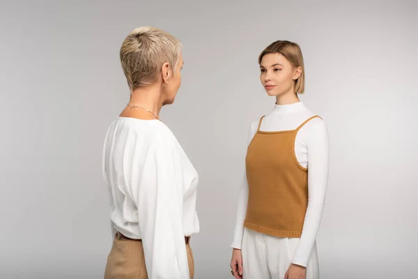 Joven hija y madre mirándose aisladas en gris — Stock Photo