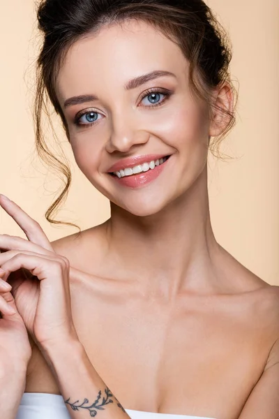 Felice giovane donna guardando la fotocamera isolata sul beige — Foto stock