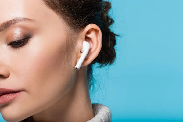 Vista recortada de mujer joven en auriculares aislados en azul - foto de stock