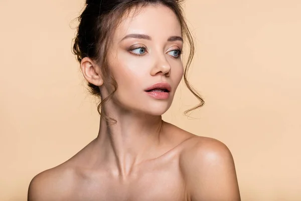 Young brunette woman with naked shoulders posing isolated on beige — Stock Photo