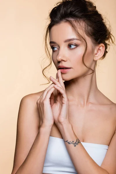 Hübsches Model in weißem Top schaut vereinzelt auf beige weg — Stockfoto