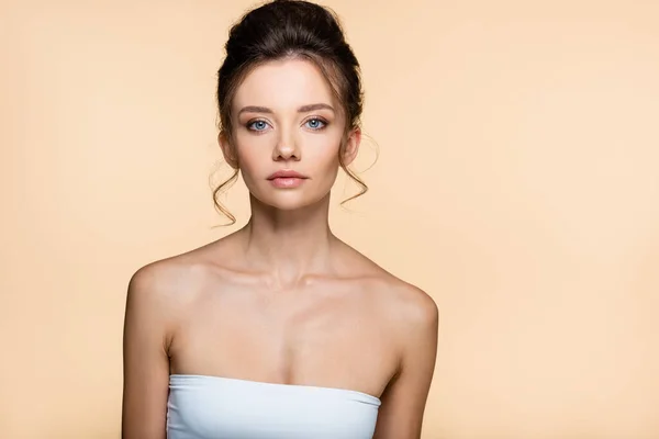 Junges Model in weißem Top blickt vereinzelt auf beige Kamera — Stockfoto