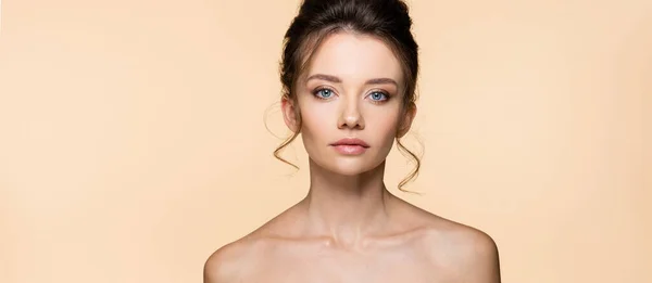 Portrait of brunette model with naked shoulders isolated on beige, banner — Stock Photo